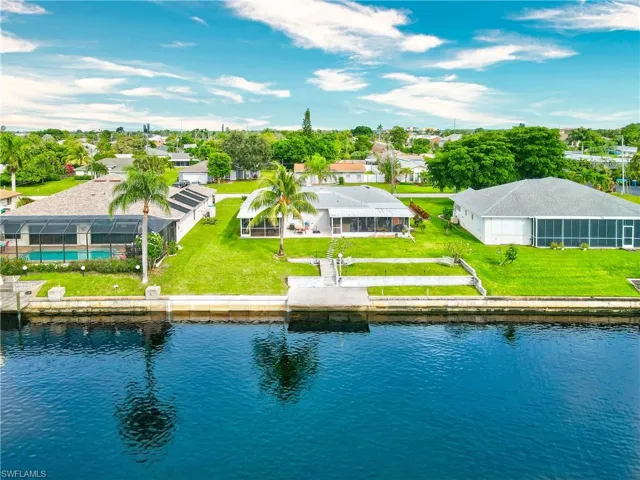 Birds eye view of property with a water view