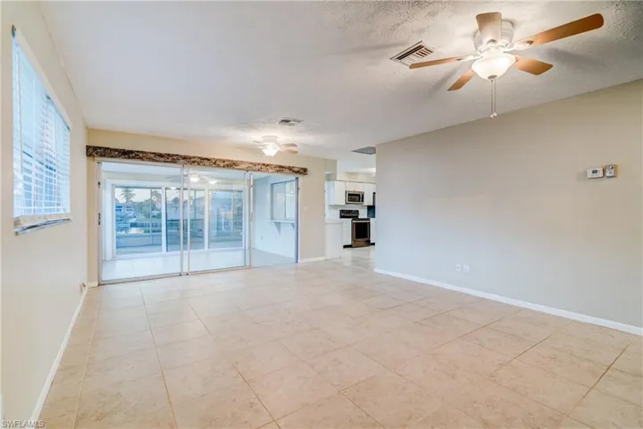 Spare room featuring ceiling fan, a textured ceiling, and light tile patterned flooring