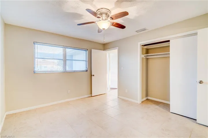 Unfurnished bedroom featuring a closet, ceiling fan, and light tile patterned floors