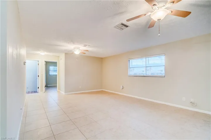 Spare room featuring light tile patterned flooring, a textured ceiling, and ceiling fan
