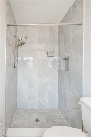 Bathroom featuring toilet and a stall shower