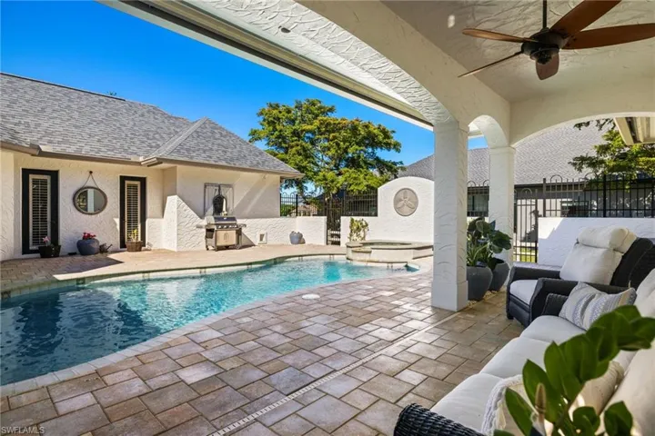 View of swimming pool featuring ceiling fan, an in ground hot tub, an outdoor hangout area, and a patio