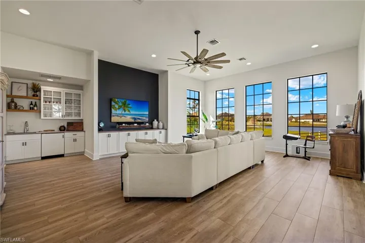 Living room featuring ceiling fan, sink, and light hardwood / wood-style flooring