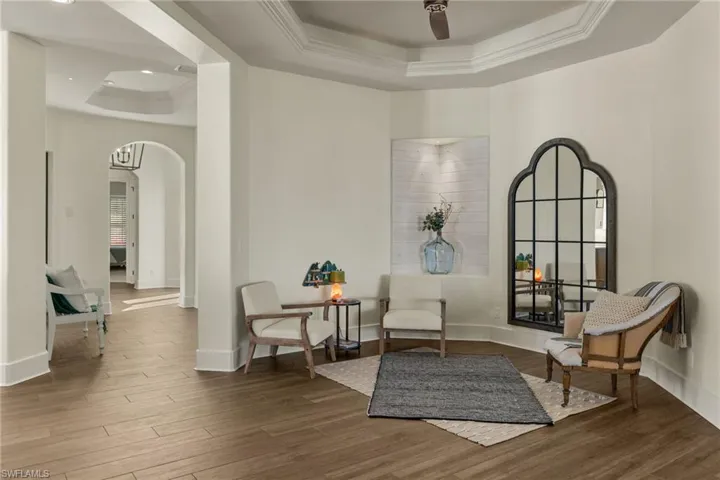 Sitting room featuring hardwood / wood-style floors, a raised ceiling, and ceiling fan