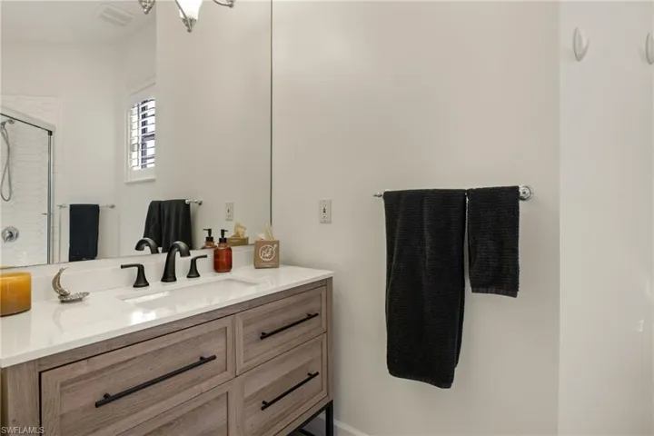 Bathroom featuring vanity and an enclosed shower