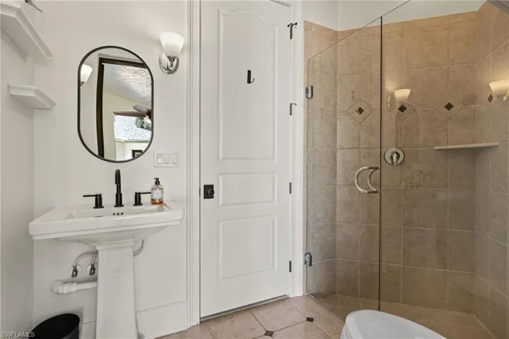 Pool Bathroom featuring tile patterned floors, toilet, and walk in shower