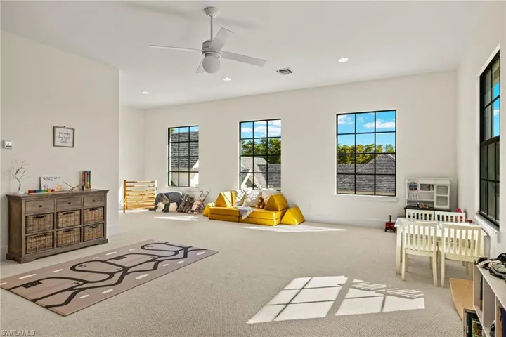 Playroom featuring ceiling fan and light carpet