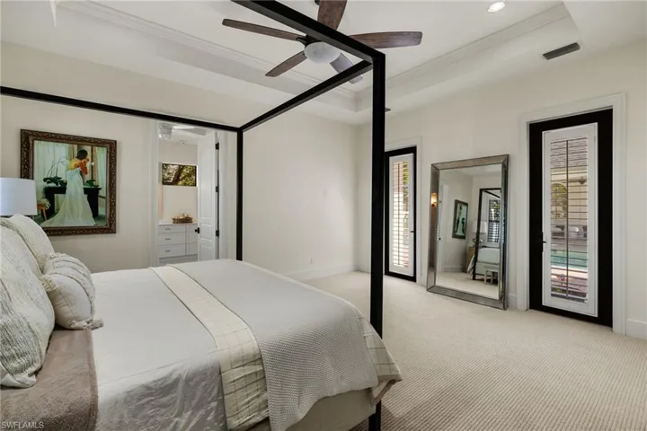 Carpeted bedroom with ceiling fan, ornamental molding, access to outside, and a tray ceiling