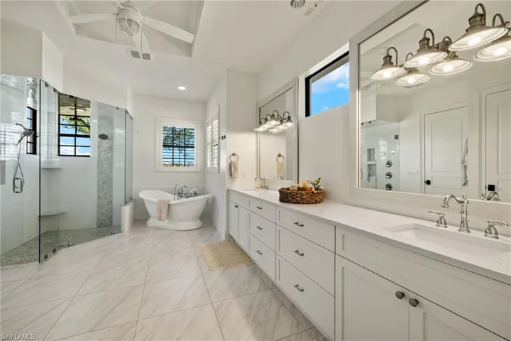 Bathroom featuring ceiling fan, vanity, and independent shower and bath