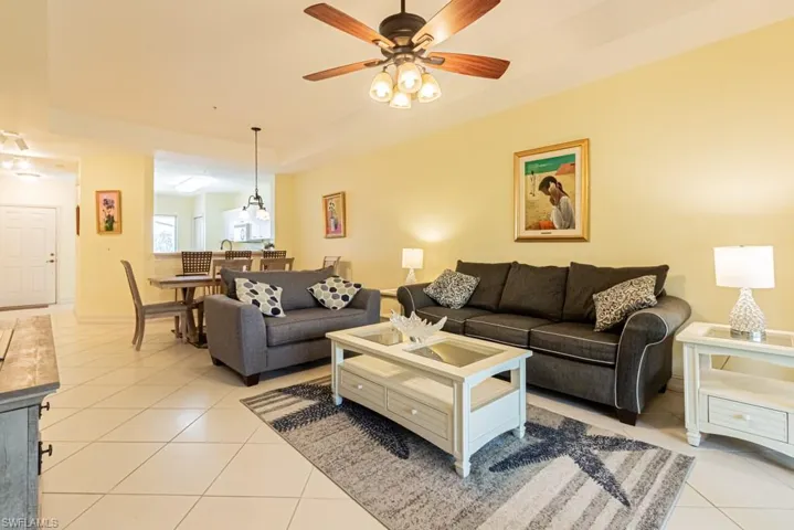 Living area with light tile patterned flooring and a ceiling fan