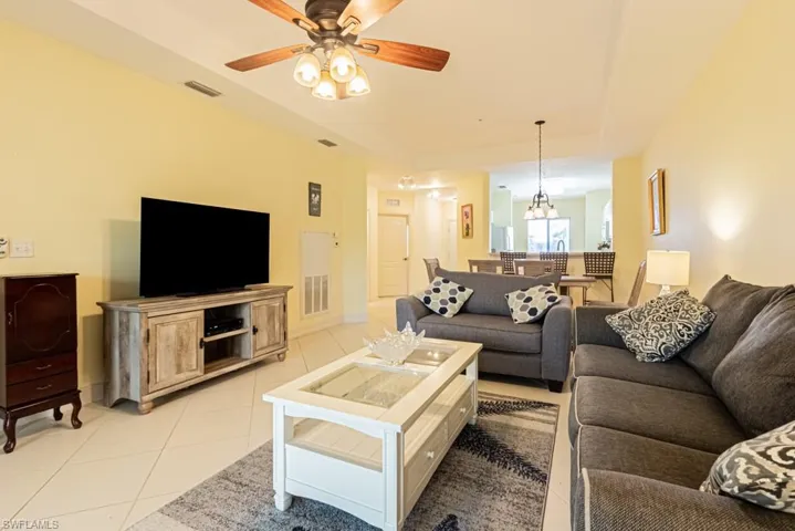 Living room featuring light tile patterned flooring and a ceiling fan