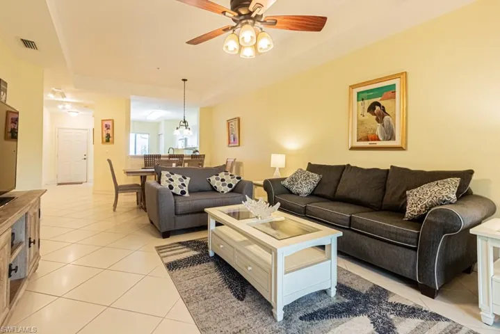 Living area featuring light tile patterned floors and ceiling fan