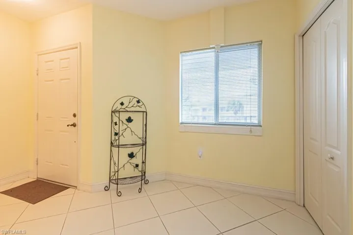 Foyer featuring light tile patterned floors and baseboards