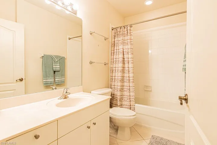 Full bath with light tile patterned floors, shower / tub combo, and vanity