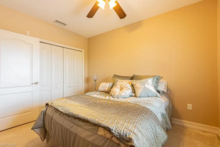 Carpeted bedroom with a closet and ceiling fan