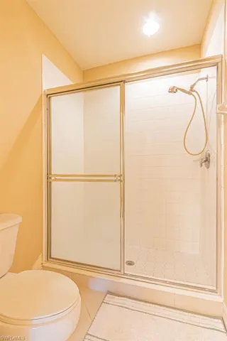 Full bathroom featuring a shower stall and tile patterned floors
