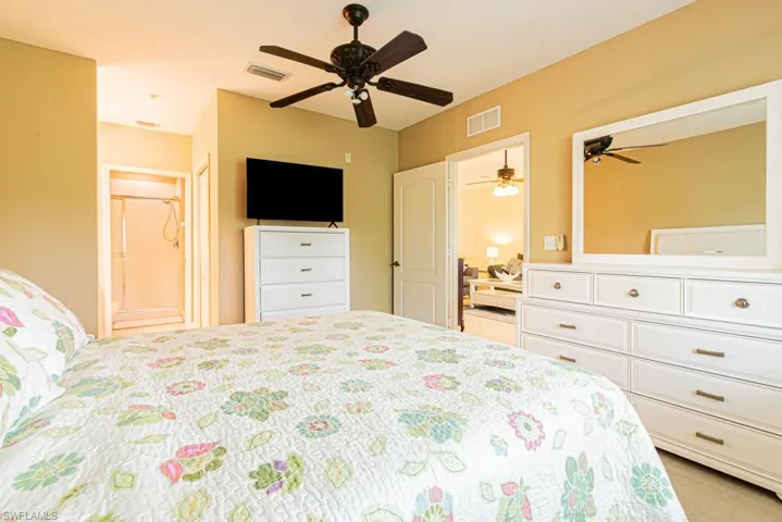 Bedroom featuring ensuite bath and a ceiling fan