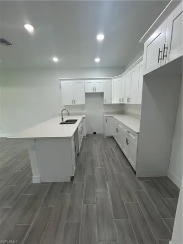 Kitchen featuring recessed lighting, white cabinets, light countertops, and wood tiled floors