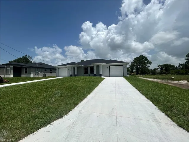 Ranch-style house featuring an attached garage, concrete driveway, a front yard, and stucco siding