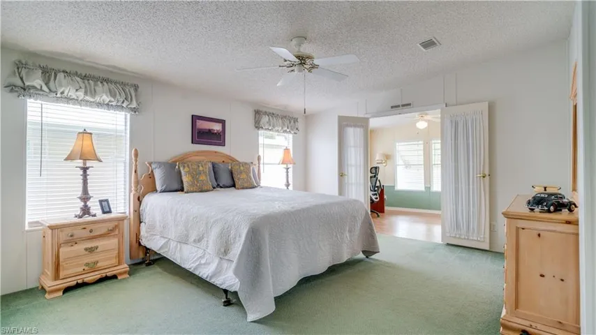 The primary bedroom will easily accommodate a chair for reading and relaxing. What is on the other side of those French doors?