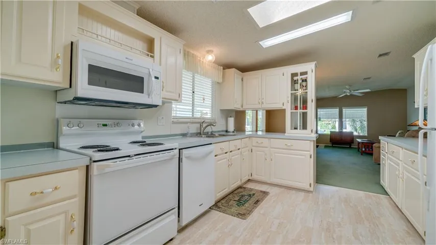 The bright and cheerful kitchen features Whirlpool and GE appliances as well a lofted ceiling with a skylight.