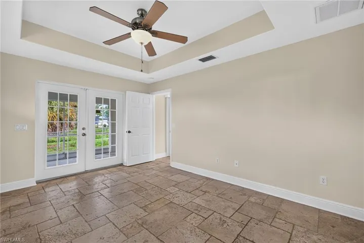 Master bedroom with lanai beyond French doors and dining room to right
