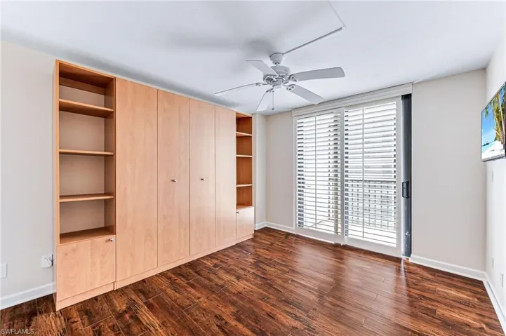 Unfurnished bedroom with dark hardwood / wood-style floors and ceiling fan