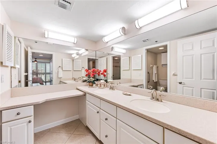 Bathroom with toilet, vanity, and tile patterned floors
