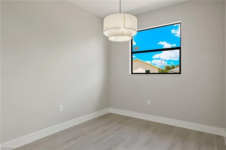 Spare room with baseboards and light wood-type flooring