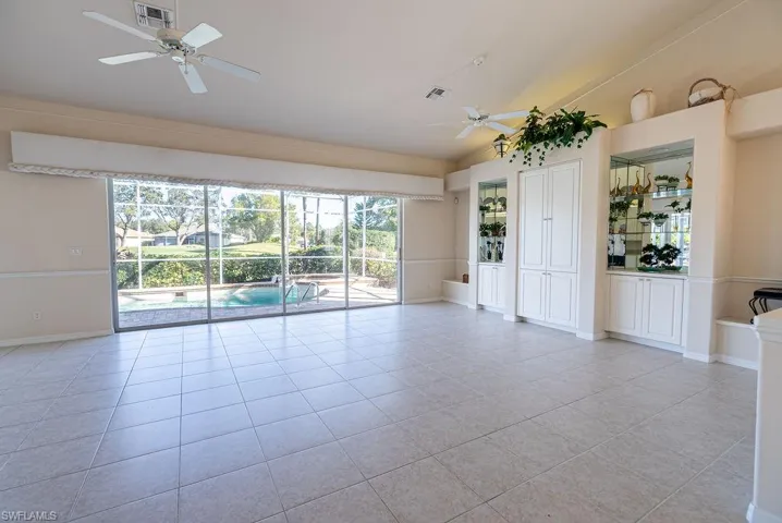 Unfurnished room with a ceiling fan, plenty of natural light, vaulted ceiling, and light tile patterned floors