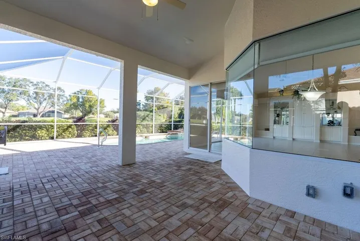 View of patio featuring a lanai, an outdoor pool, ceiling fan, and a sunroom