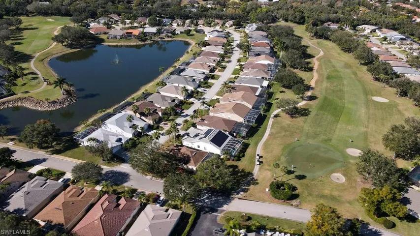 Aerial view of property and surrounding area with a local golf course, nearby suburban area, and a nearby body of water