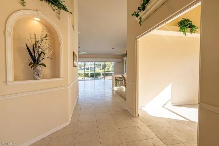 Hall with light tile patterned floors and baseboards
