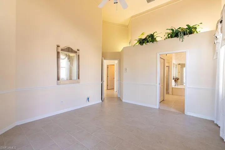 Spare room with ceiling fan and a towering ceiling