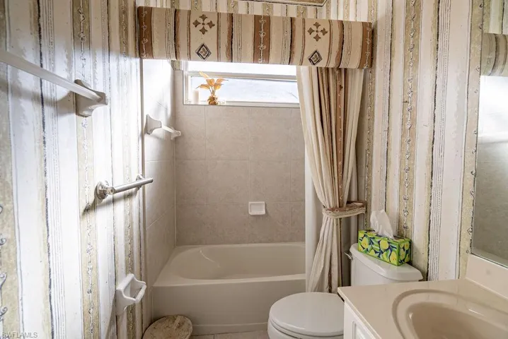 Full bathroom featuring shower / bath combo with shower curtain and vanity
