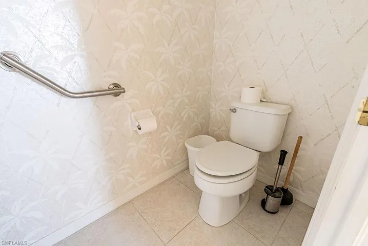 Bathroom with tile patterned flooring and wallpapered walls