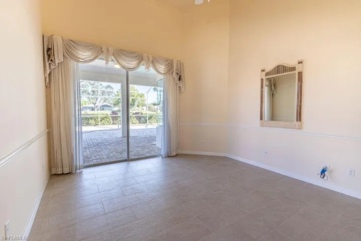 Unfurnished room with a high ceiling and baseboards