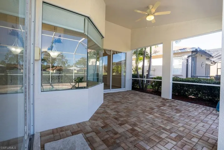 Unfurnished sunroom featuring a ceiling fan and a patio area
