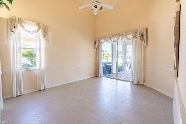 Spare room featuring high vaulted ceiling, a ceiling fan, and light tile patterned flooring