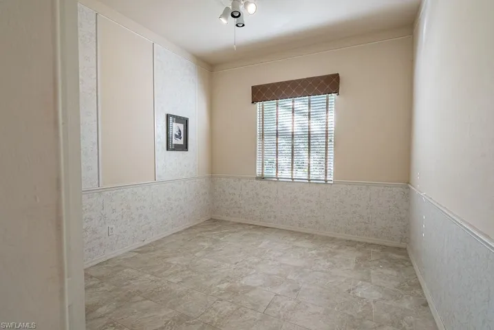 Spare room featuring wainscoting and wallpapered walls