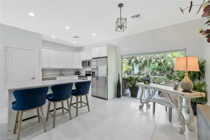 Kitchen with light countertops, backsplash, white cabinets, visible vents, and appliances with stainless steel finishes
