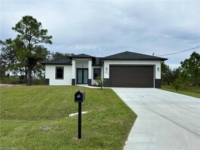 View of front of property with a front lawn and a garage
