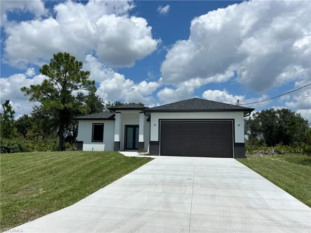 View of front of home featuring a garage and a front lawn
