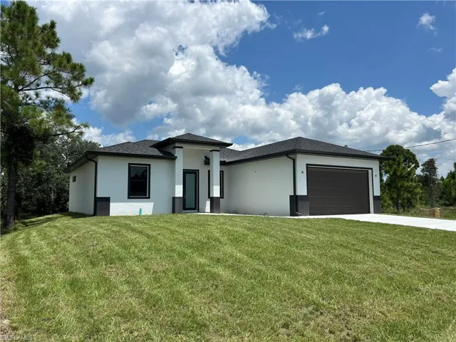 Prairie-style home with a garage and a front lawn
