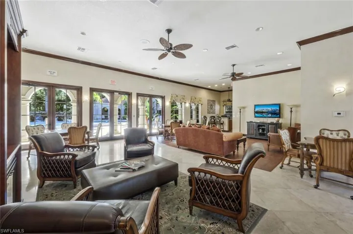 Living room featuring crown molding, french doors, and ceiling fan