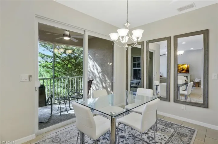 Tiled dining room featuring ceiling fan with notable chandelier