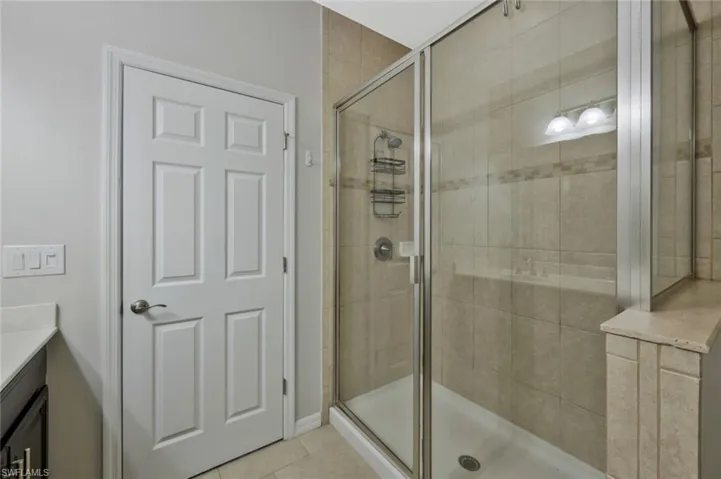 Bathroom featuring vanity, tile patterned floors, and walk in shower