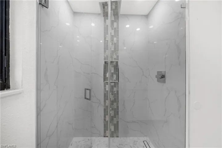 Bathroom with a marble finish shower