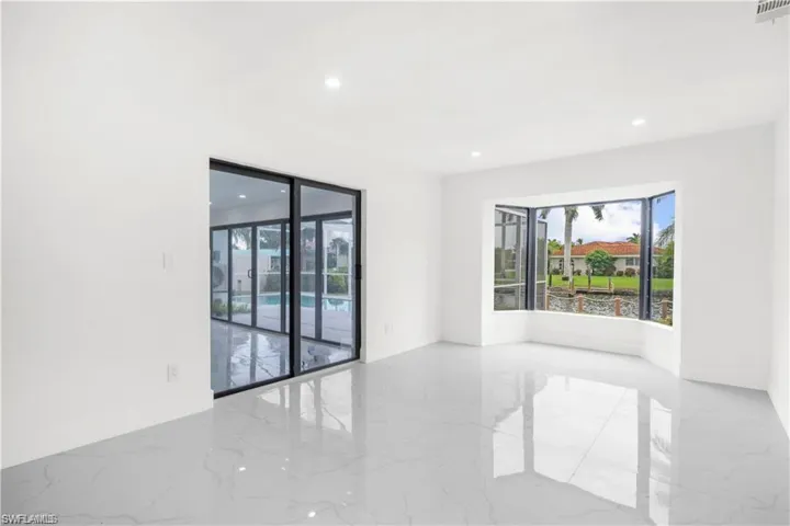Unfurnished room with marble tiled floors and recessed lighting