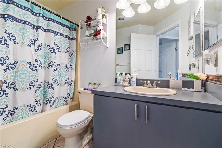 Bathroom featuring vanity and shower / bath combination with curtain